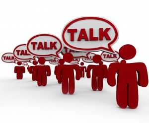 Talk word in speech bubbles on red 3d people to illustrate communicating or sharing a message or information in a crowd or social group or connected network, forum or class
